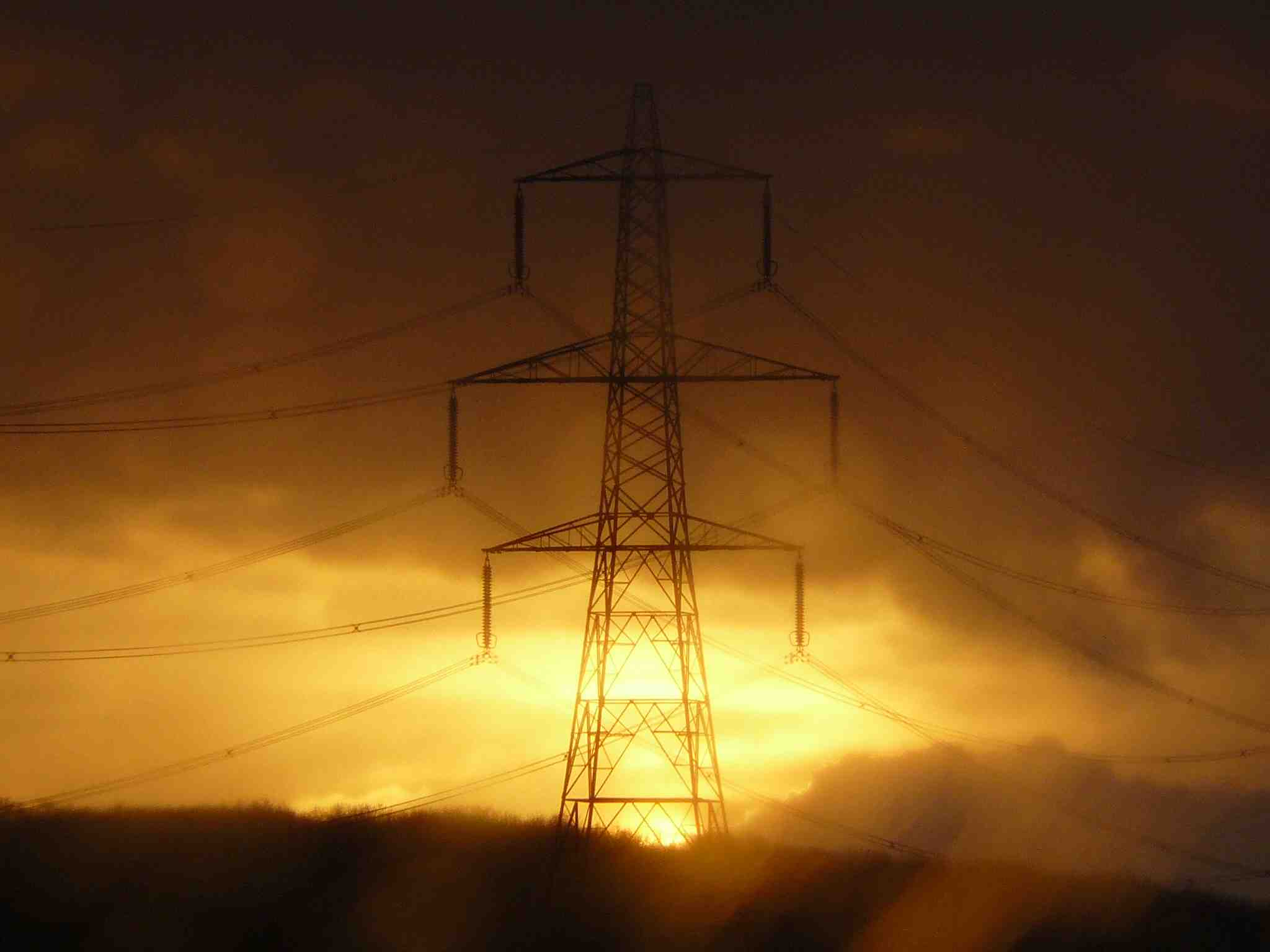 Imgae of the sun setting behind a pylon.